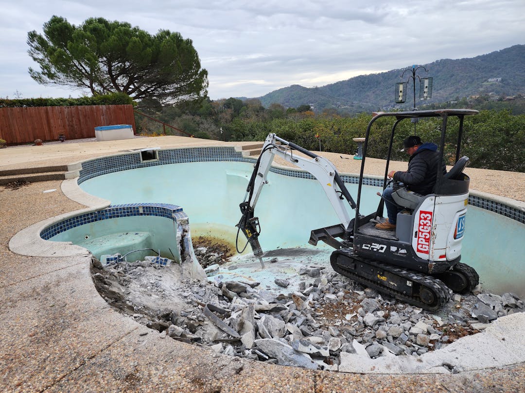Bulldozer drilling a pool